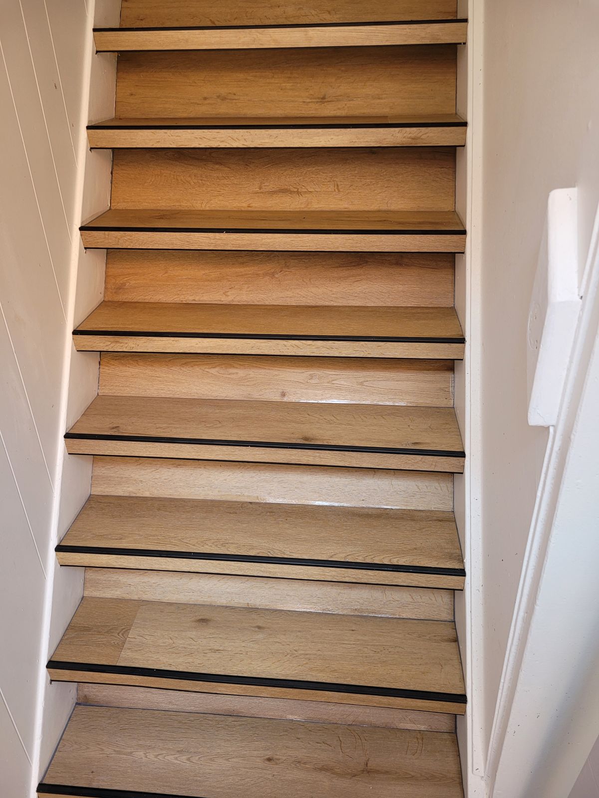 Dezelfde trap na de renovatie, met PVC in eikenlook en zwarte neuzen